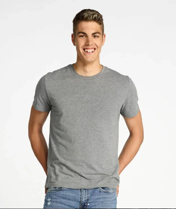 Smiling young man wearing a plain gray t-shirt and blue jeans against a white background